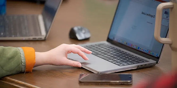 A close up of a hand using a laptop